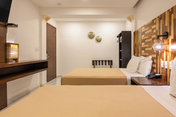 A hotel room with a bed, bedside table, lamp, and a wooden wall panel. - Marvic Hotel (Playa del Carmen)