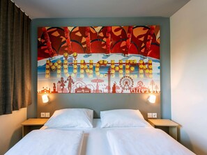 A hotel room with two beds, a large wall mural of Munich, and two bedside lamps. - B&B Hotel München City-west (Munich)