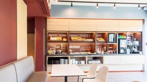 A breakfast area with seating and a buffet counter. - B&B Hotel München City-west (Munich)