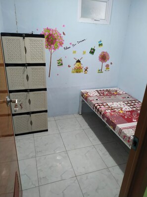 Un dormitorio con cama, un armario y una pared decorada con pegatinas.