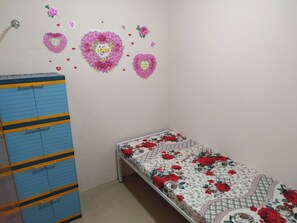 A bedroom with a bed, a wardrobe, and decorative wall stickers. - Eiffel Residence Cideng by Zuzu (Jakarta)