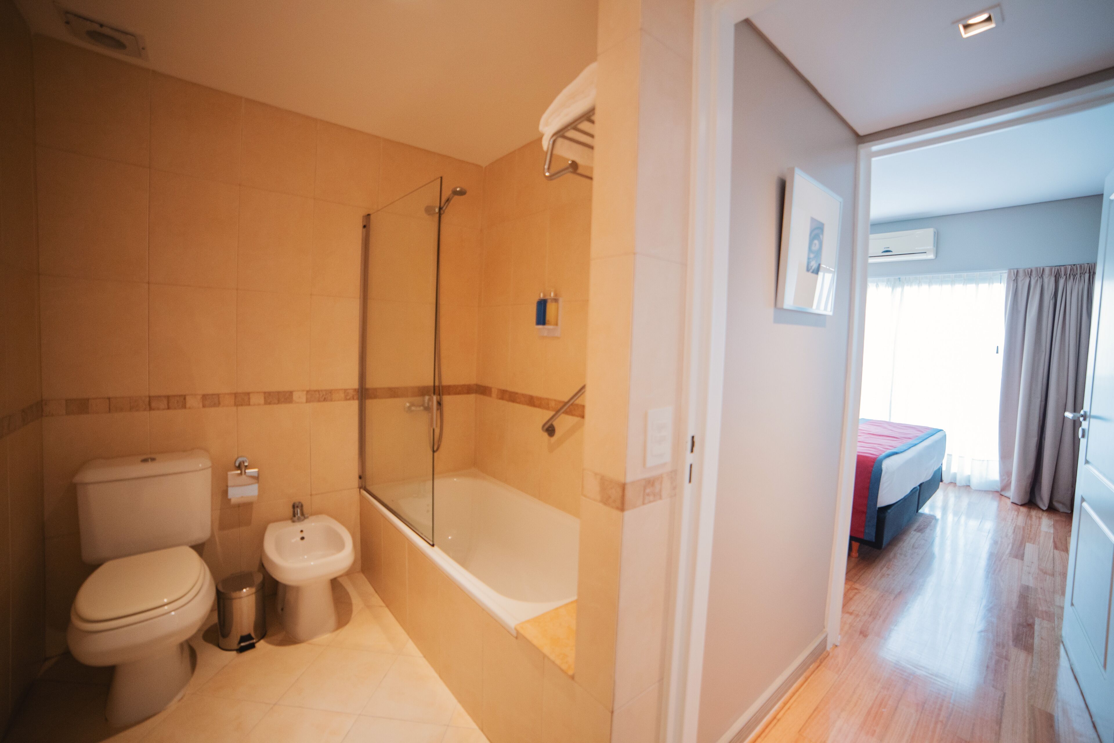 A bathroom with a toilet, bidet, and bathtub.