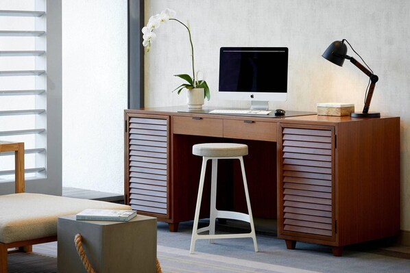 A modern desk with a computer, a lamp, and a potted orchid. - Westdrift Manhattan Beach, Autograph Collection (Manhattan Beach)