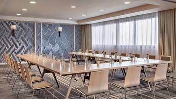 A conference room with a long table, chairs, and a patterned wall.