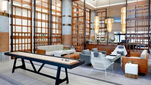 Ein modernes Interieur mit Poolbillard, Sitzgelegenheit und großen Fenstern.