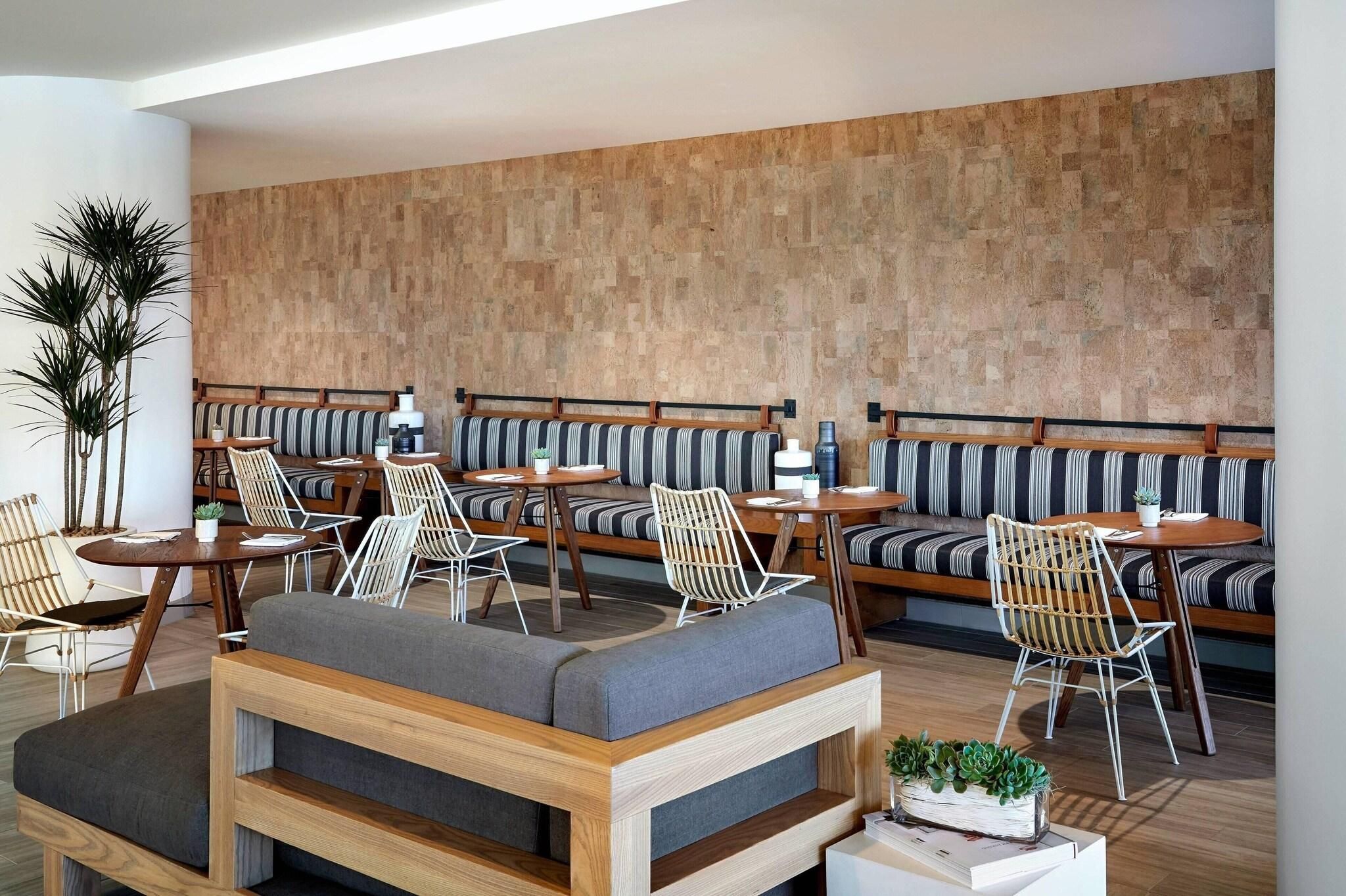 A modern interior with a wooden wall, striped seating, and a central wooden sofa.