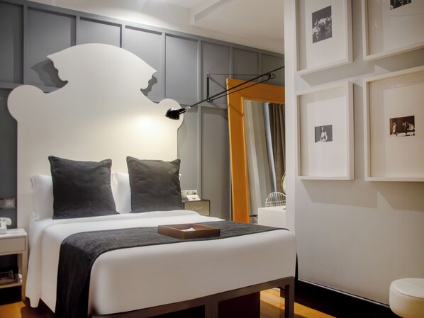A modern bedroom with a large bed, a bedside table, a lamp, and framed pictures on the wall. - Brown S Downtown (Lisbon)