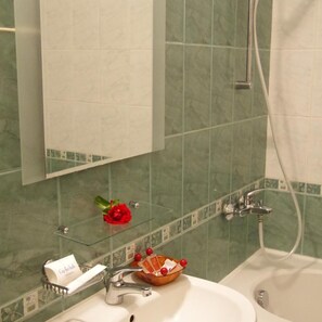 A bathroom with a sink, mirror, shower, and a glass shelf with toiletries. - Joya Park Complex (Varna)