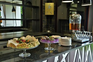 Un mostrador de buffet con diferentes alimentos y un dispensador de bebidas.