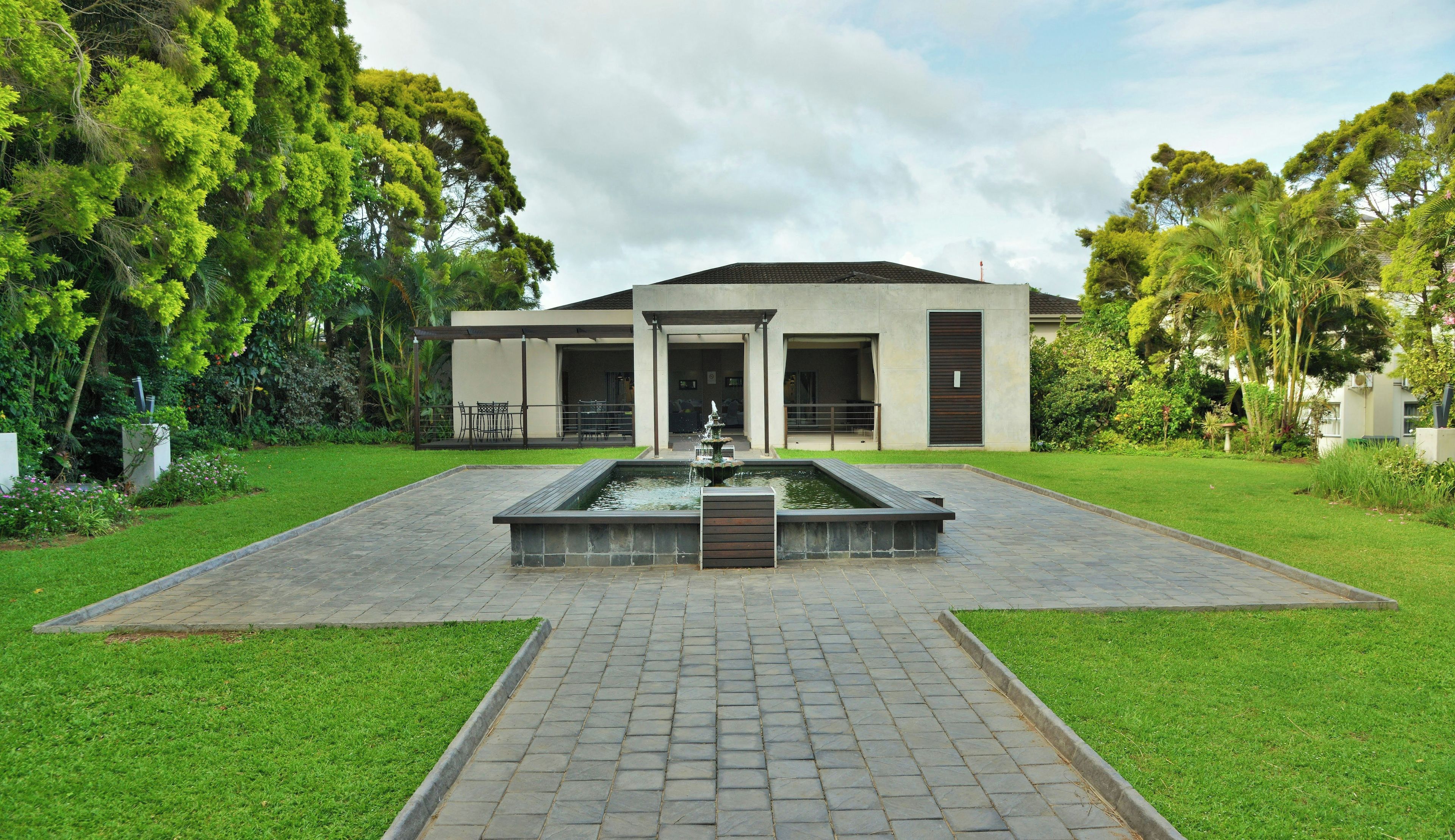 A modern building with a central courtyard, a fountain, and a well-maintained lawn.
