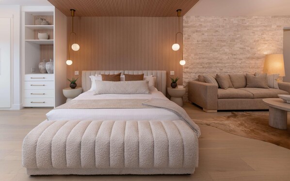 Une chambre moderne avec un grand lit, un canapé et une table de chevet.
