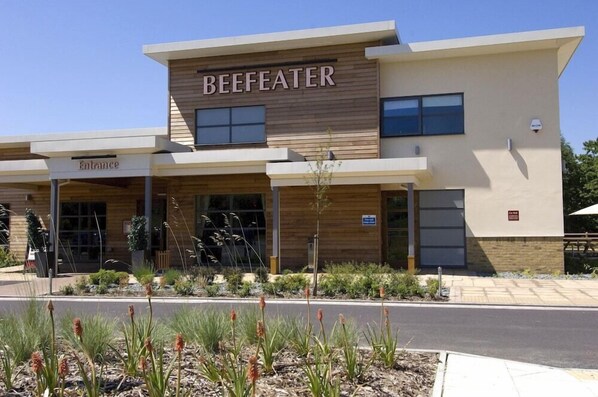 Un bâtiment moderne avec une enseigne indiquant « BEEFATER » et une autre indiquant « Entrée ».