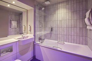 Un baño moderno con un espejo grande, dos lavamanos, una bañera y una ducha.