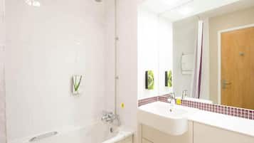 A modern bathroom with a bathtub, a sink, and a mirror.