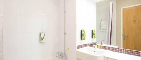 A modern bathroom with a bathtub, a sink, and a mirror.