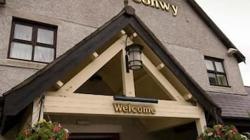 A building with a sign reading 'Afon Conwy' and a welcoming entrance.