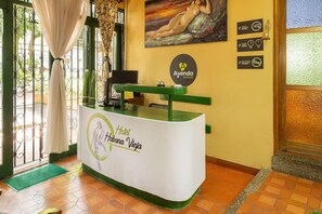 Uma mesa de recepção com uma placa indicando 'Hotel Habana Vieja' e 'Ayenda Hoteles'.
