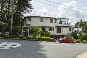 Un edifici de dues plantes amb façana blanca i un balcó al pis superior.