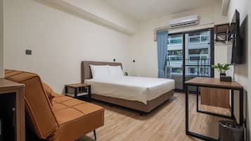 Habitación doble Deluxe, balcón | Escritorio, cortinas blackout y tabla de planchar con plancha