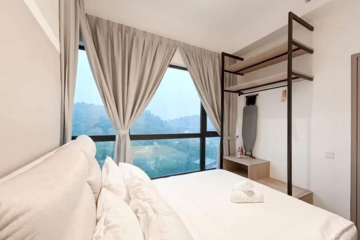 Une chambre d’hôtel avec un lit, une fenêtre avec des rideaux, un lit superposé et une vue sur les montagnes.
