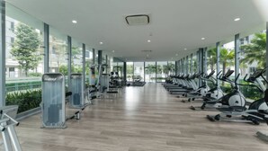A gym with cardio machines, weight machines, and a mirrored wall. - United Point Residence KL Lifestyle (Kuala Lumpur)