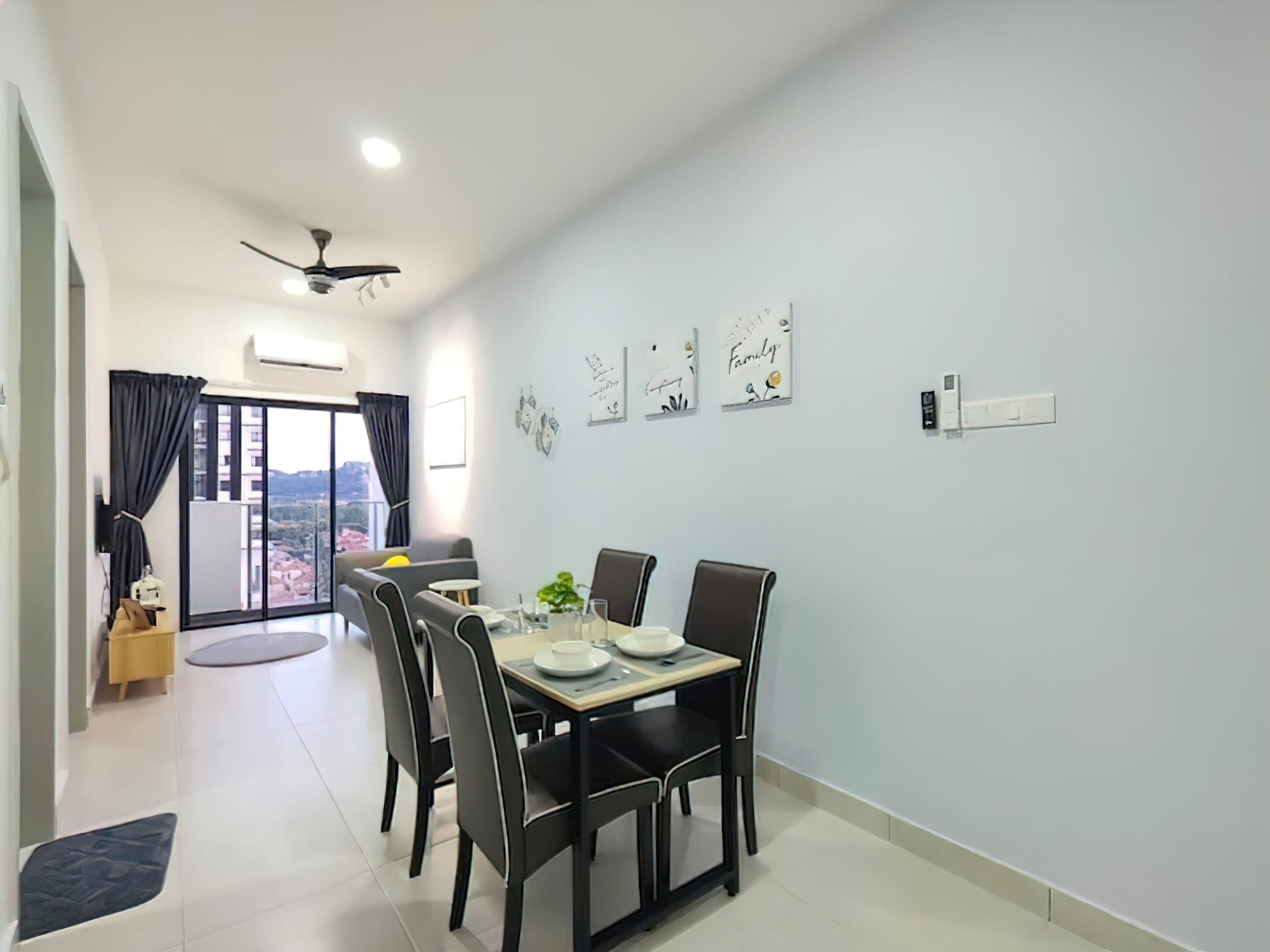 A dining area with a table set for four, a ceiling fan, and artwork on the walls.