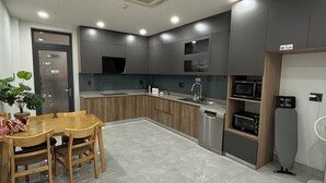 Una cocina moderna con comedor, que incluye un microondas integrado, horno y un refrigerador pequeño.