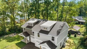 A two-story house with a garage, a covered porch, and a fenced yard.