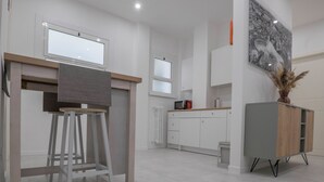 A modern kitchen with white cabinets, a wooden countertop, and a built-in oven. - RAPHAEL ROOM (Roma)