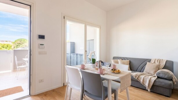 A dining area with a table, chairs, and a sofa. - Dimora Anna - Beachfront Apartment (Bari)