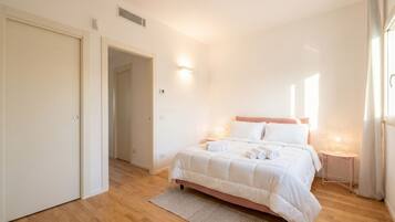 Una camera da letto con un letto, un comodino, una porta e una finestra.