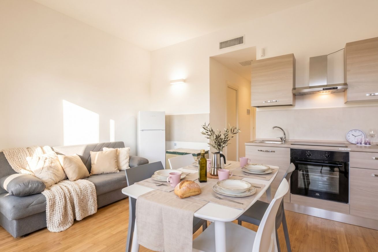 Une cuisine moderne avec un coin repas, un canapé et une table mise pour le repas.