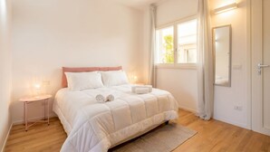 A bedroom with a bed, bedside table, window, and a door. - Dimora Anna - Beachfront Apartment (Bari)