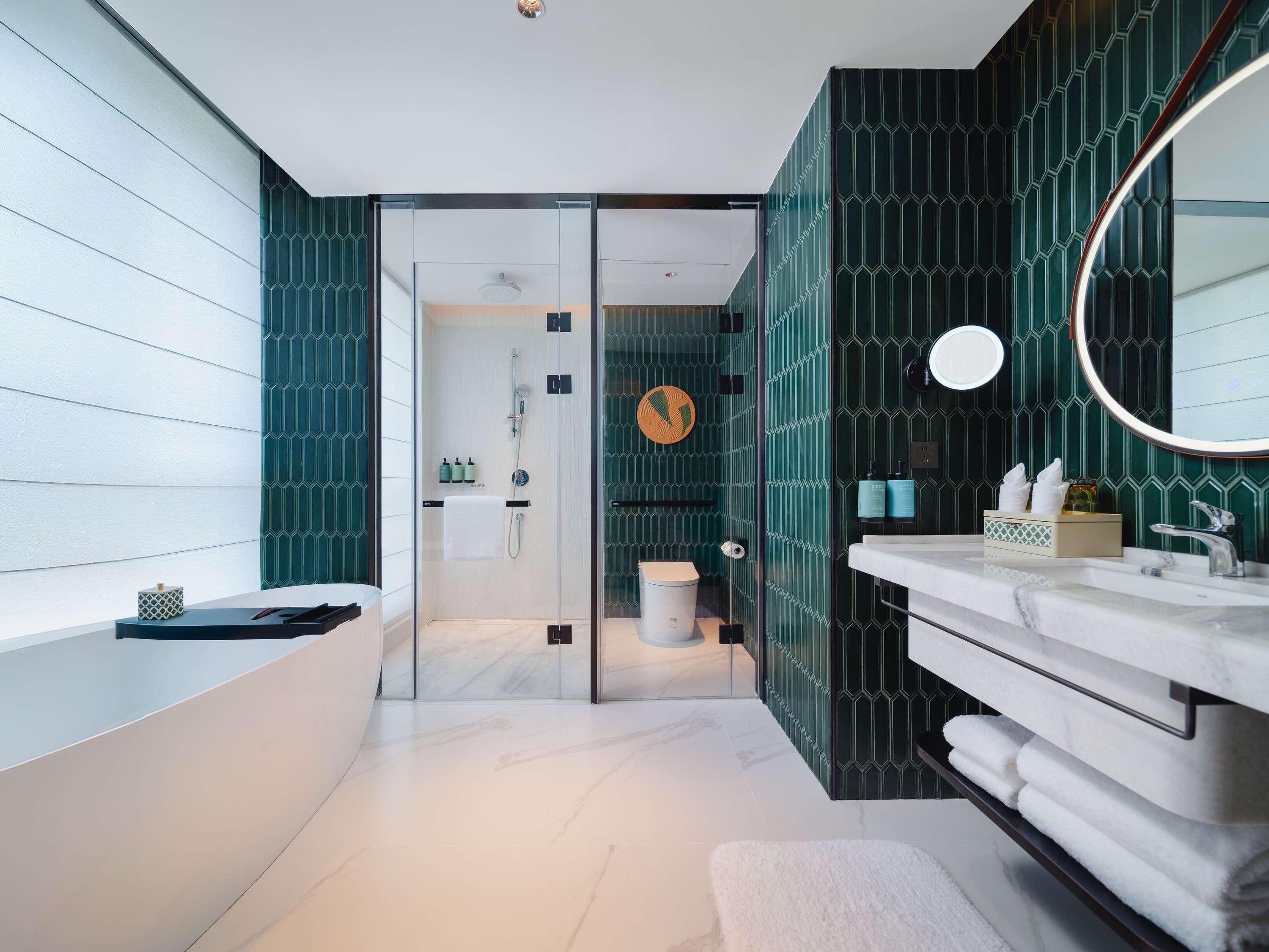 Ein modernes Badezimmer mit einer gläsernen Duschkabine, einem Waschtisch mit Spiegel und einer Toilette.
