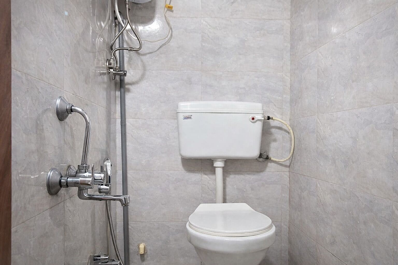 A bathroom with a toilet, a shower, and a wall-mounted sink.