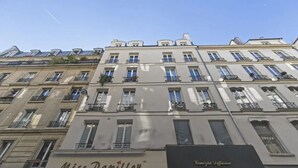 Un edificio a più piani con un negozio vetrina con la scritta “Miss Papillon” e un altro negozio chiamato “Venegia Diffusion.”