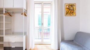 A room with a white wardrobe, a grey sofa, and a window with curtains. - Barrio 133 - Double Bedroom in Center (Naples)
