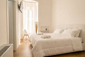 Une chambre à coucher avec un lit, une chaise, une étagère et un radiateur.