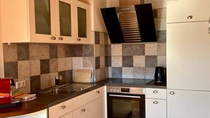 A kitchen with a built-in oven, a coffee maker, and a microwave.