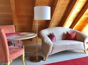 Une pièce chaleureuse avec une table ronde, un canapé et un lampadaire.