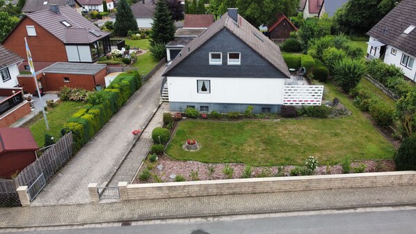A residential house with a sloped roof, a small front yard, and a paved driveway. - Riding & recreation in the Weserbergland (Salzhemmendorf)