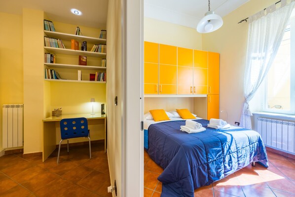 A bedroom with a bed, a desk, and a bookshelf. - Casa Nostos Alabardieri by Napoliapartments (Naples)