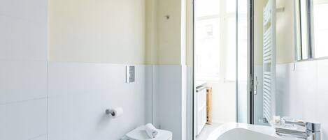 A modern bathroom with a toilet, bidet, and sink.