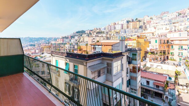 Un balcone con vista su una zona urbana densamente popolata e con diversi edifici.