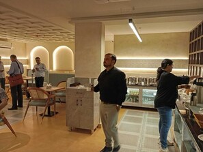 A modern interior with a bar area, seating, and a counter. - Hotel La Premier (Hyderabad)