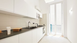 Een moderne keuken met witte kastjes, een zwart aanrechtblad en een inbouwoven.