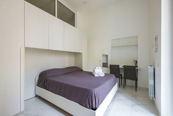 A bedroom with a bed, a desk, and a chair. - Marcellino Comfort House by Napoliapartments (Naples)