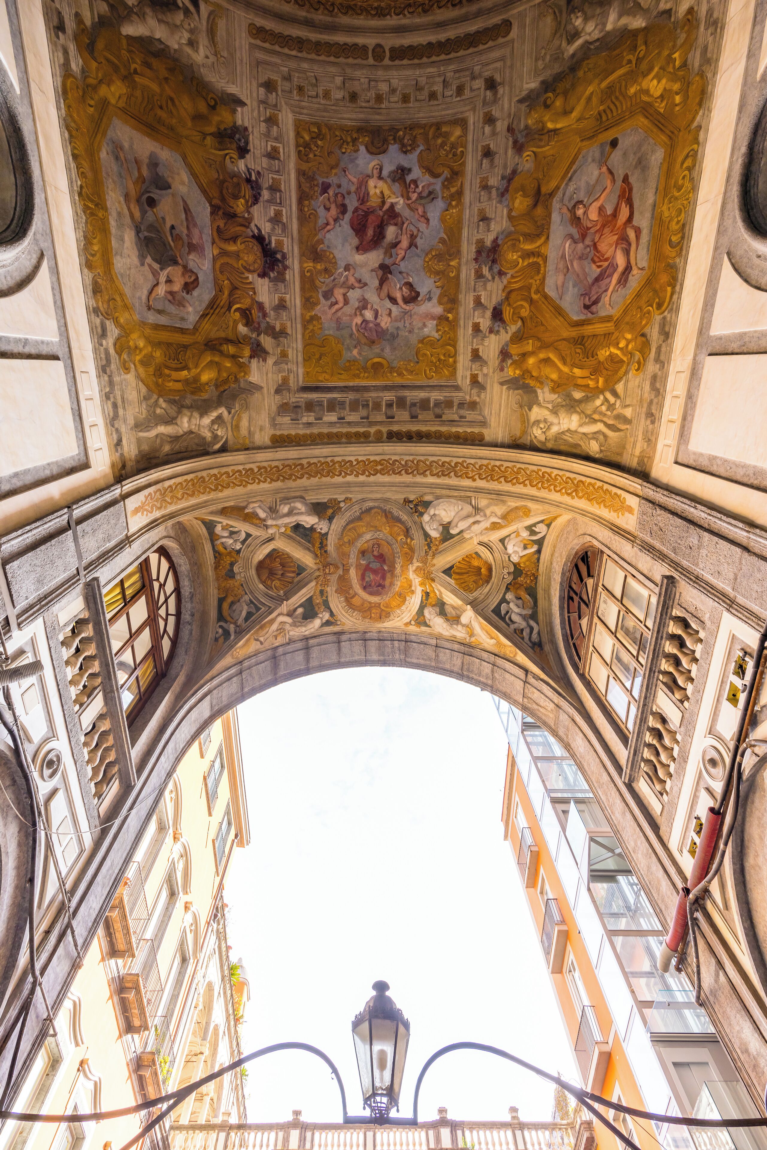 An ornate architectural ceiling with intricate frescoes and a central circular design.