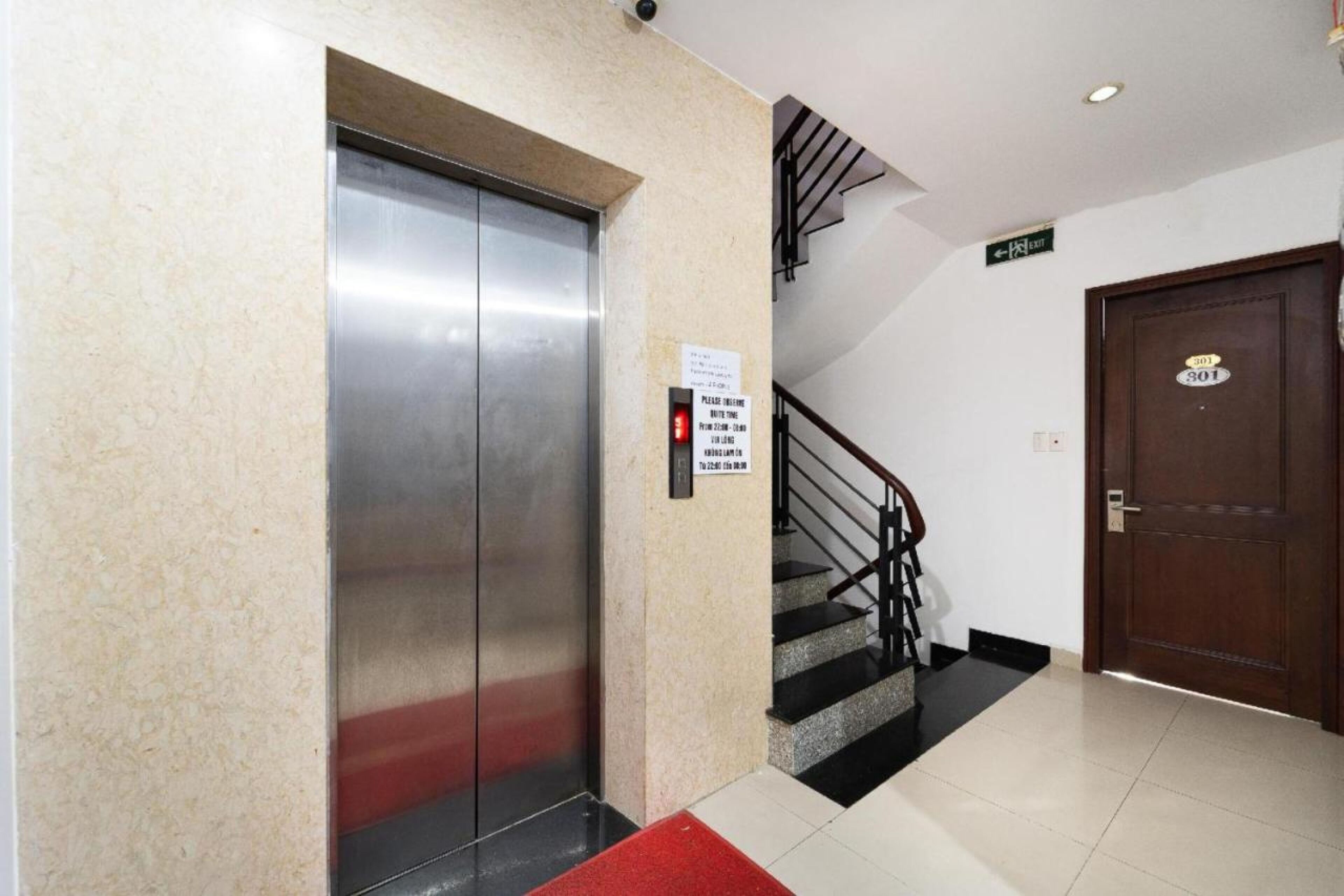An elevator, a staircase, and a door with a sign above it.