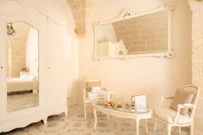 A room with a bed, a mirror, a table with a teapot, and two chairs. - Marchesa – Two-Bedroom Suite with Panoramic Terrace in the Historic Center (Monopoli)